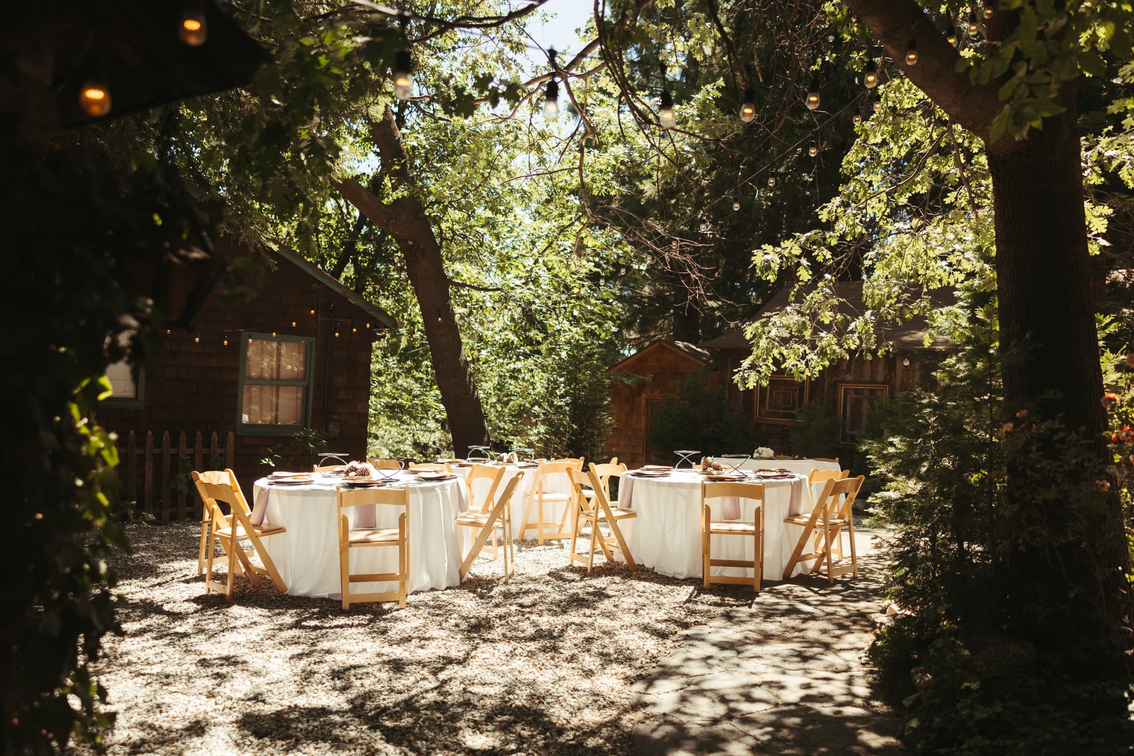 Tables set for a private dinner among the trees at Willow Woods Park