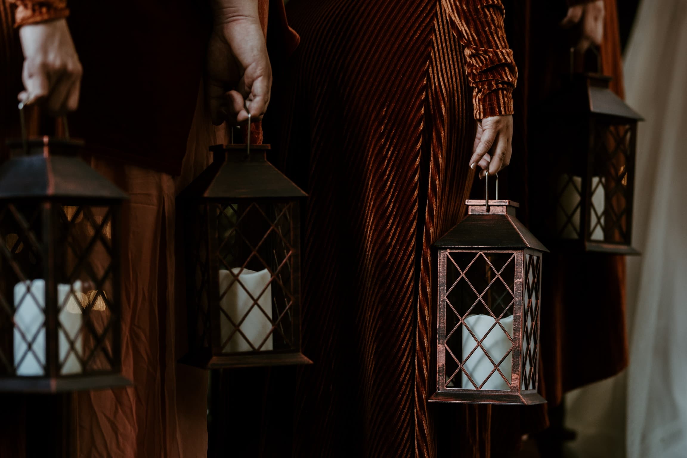Lanterns carried through the trees at Willow Woods Park after dark